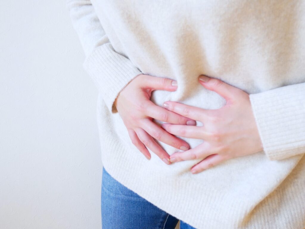 お腹を押さえる女性